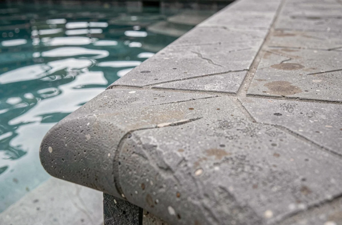 Détail du bord en béton estampé au niveau de la margelle d'une piscine extérieure